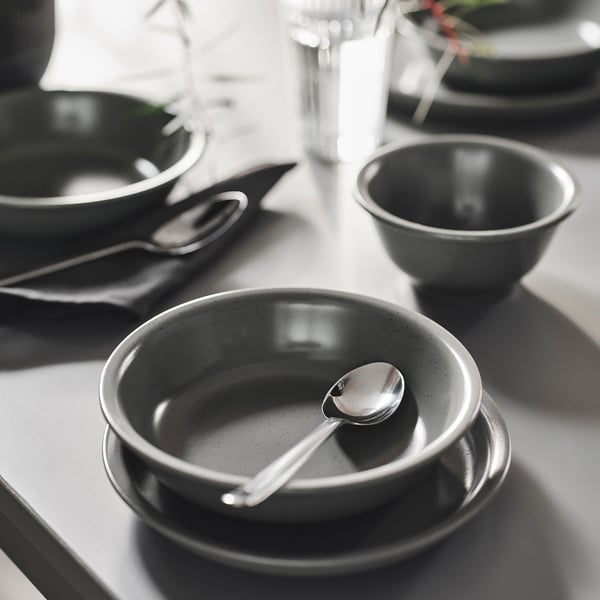 Greyscale DAGGASTER stoneware bowls vary in size, with metallic spoons, suitable for serving soups and desserts, arranged together on a table.