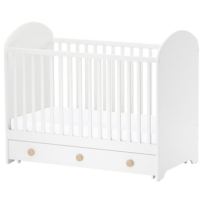 White GONATT baby crib with wooden knobs, arched ends, and bottom storage drawer.