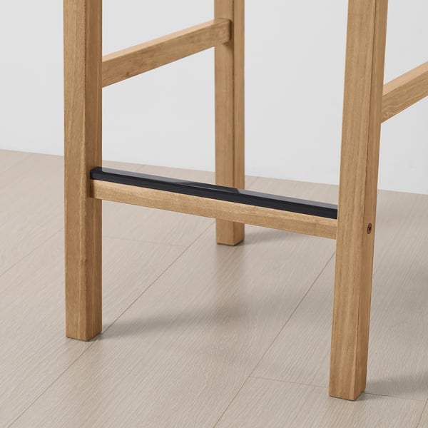 Modern wooden dining table with sturdy light pine legs and sleek black support beam.