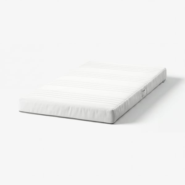 A white JÄTTETRÖTT baby mattress. Its rectangular, with a smooth, padded surface and child-safe zippers.