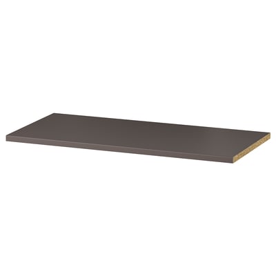 A KOMPLEMENT shelf in dark grey colour. Its rectangular, flat, and made of particleboard with a smooth paper foil surface.