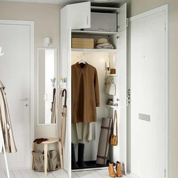 Open storage closet with brown jacket, shoes, and bags, showing organised entryway with hanging storage and adjustable feet.