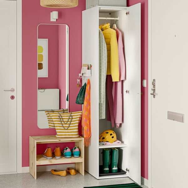 Bright pink hall with LASTARE wardrobe, shoes, bags, and mirror. Wardrobe open, showing colourful clothes and boots.