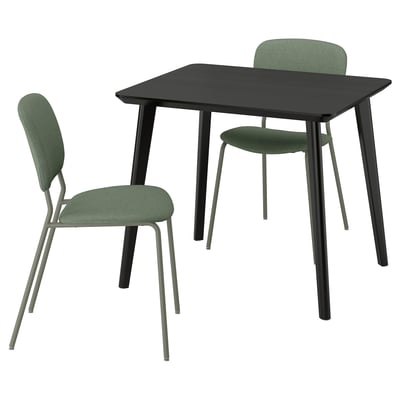 Modern black dining set with two green chairs. Table sleek legs, chairs have comfy upholstered seats and backs.