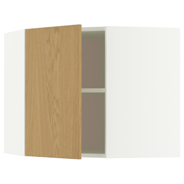 A white METOD corner cabinet with an oak veneer door partially open, revealing an adjustable shelf inside.
