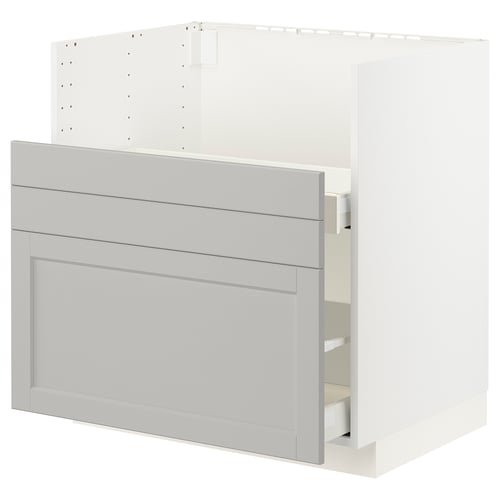 A light grey METOD kitchen cabinet with wooden fronts and bevelled edges, featuring two drawers: a full-extension drawer and a partially open drawer.