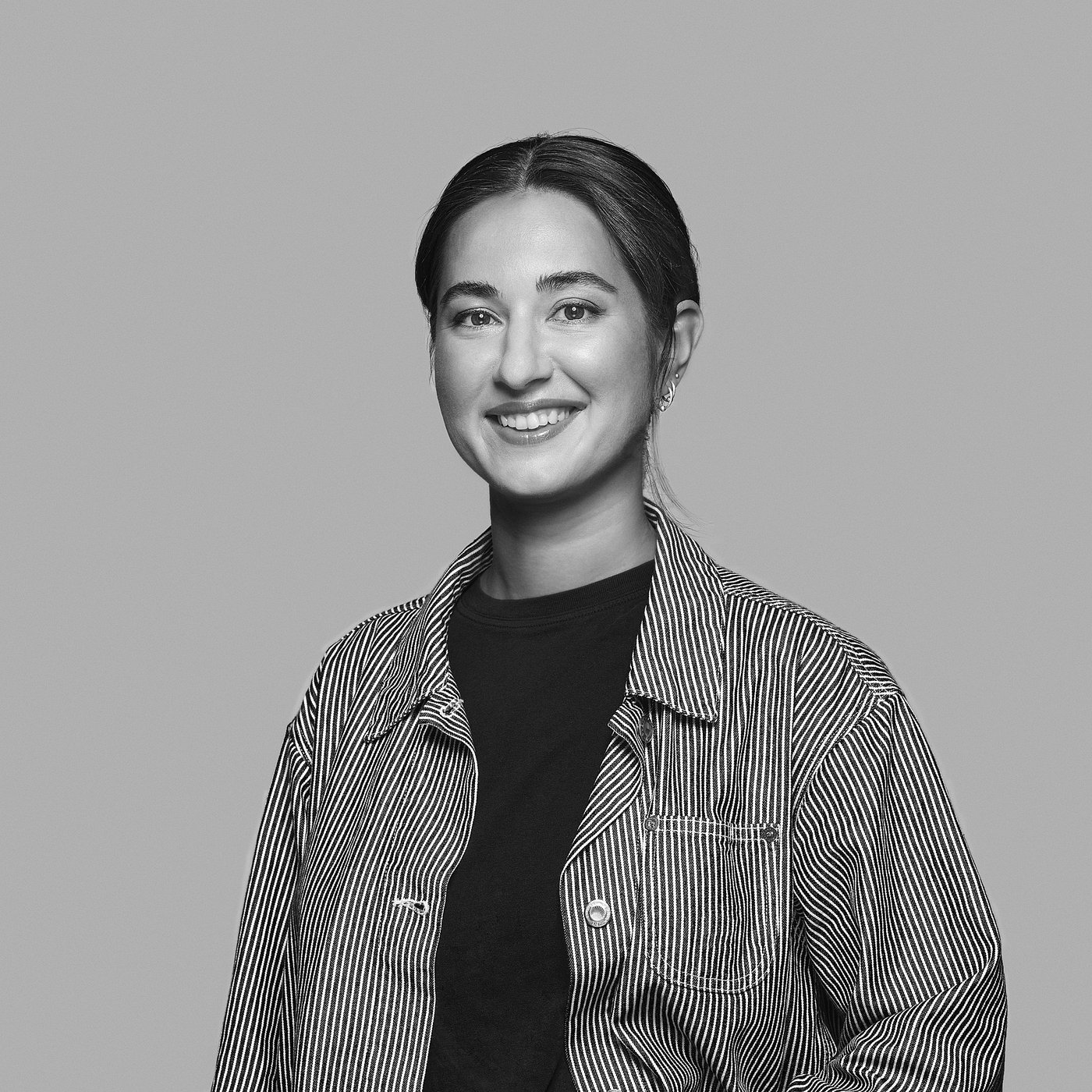 Black and white portrait of smiling Darja Nordberg wearing a striped shirt.
