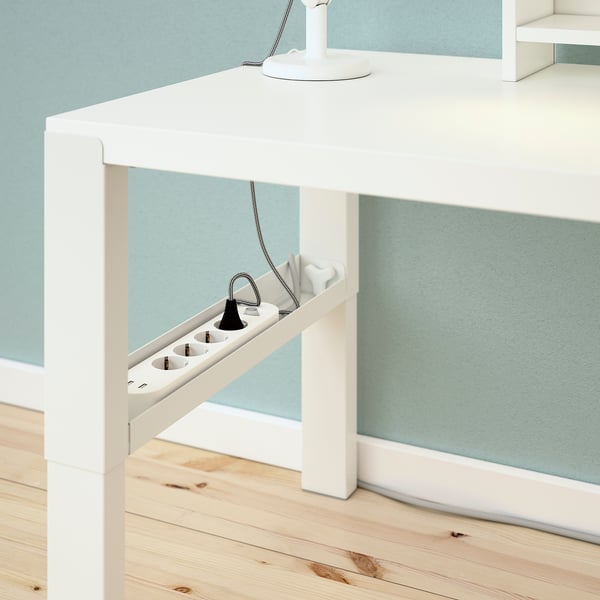 White desk with adjustable height, cable trays visible.