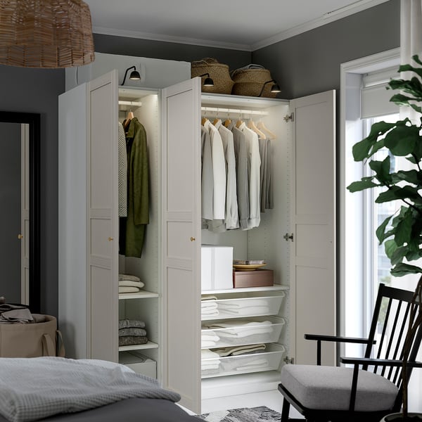 A modern closet with hanging clothes, shelves, and drawers, featuring mesh baskets and adjustable interiors.