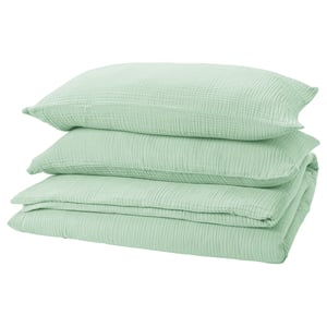A stack of four green pillowcases made from soft, breathable 100% organic cotton, featuring an envelope closure design.