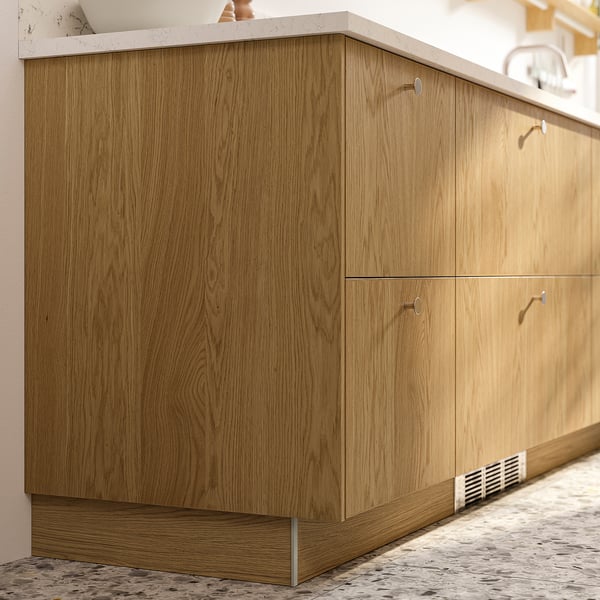 Wooden kitchen cabinet in light brown. Four doors with modern, minimalist handles. Slim, rectangular design.