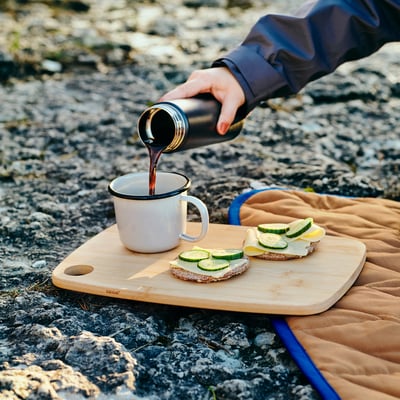 Light brown, bamboo cutting board with a hole, rectangular shape.