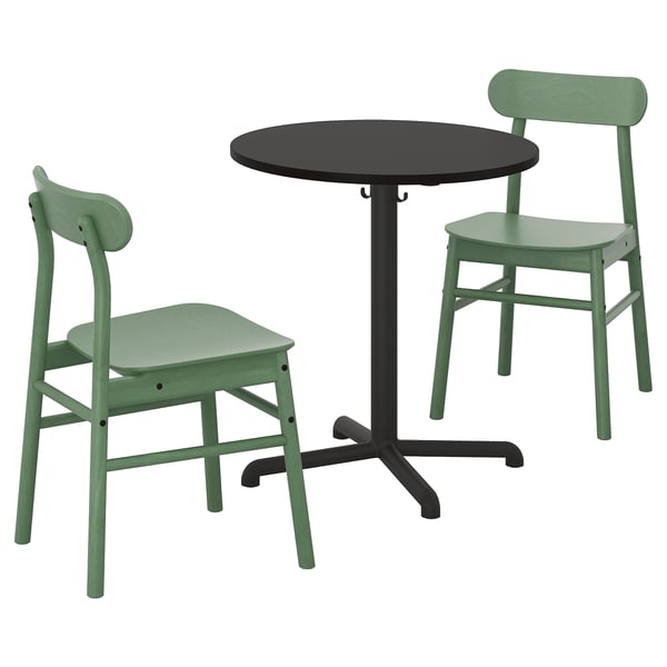 A STENSELE dining set. It includes a black round table with a metal base, and two green chairs with wooden seats.