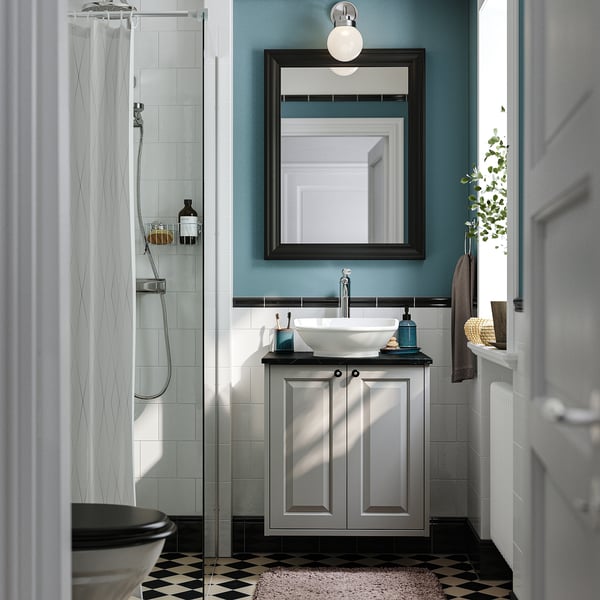 Modern bathroom with TÄNNFORSEN vanity, grey. Vessel sink, silver tap, bevelled cabinetry against blue/black/white tile backdrop.