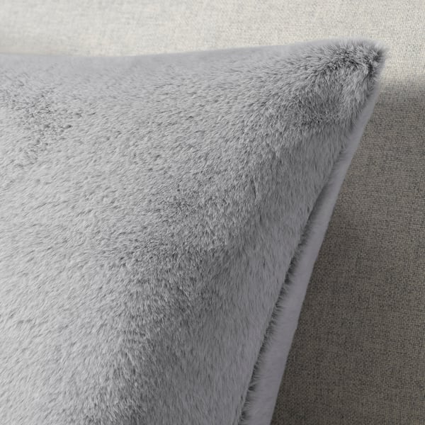 Close-up of soft, fluffy grey recycled polyester cushion cover on couch.