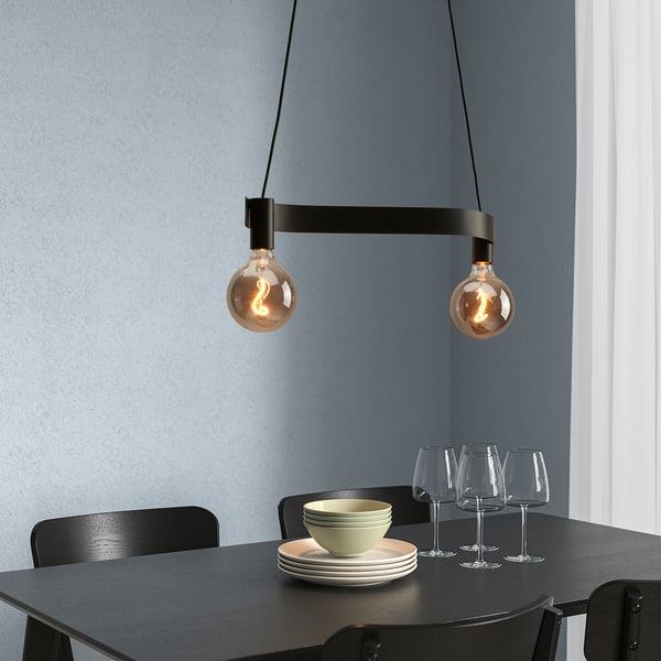 Black wavy lamp with led bulbs over dining table.