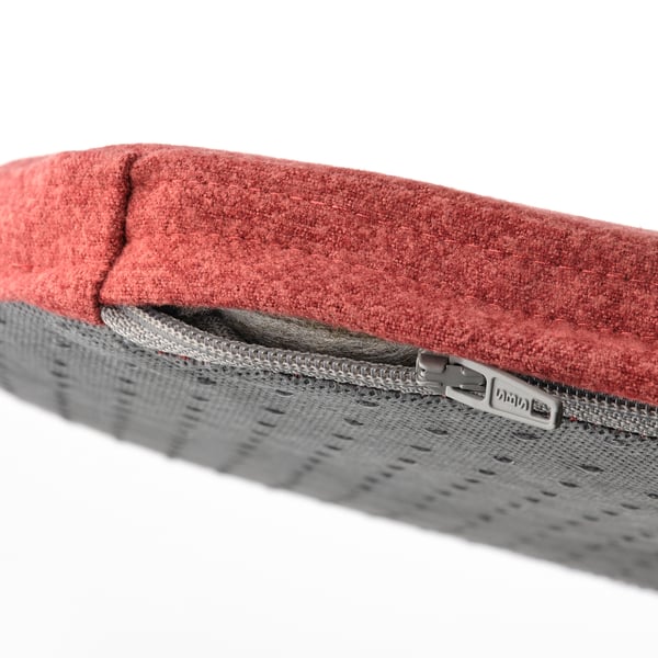 Close-up of recycled polyester chair pad, red on top, gray underneath, with zipper detail.