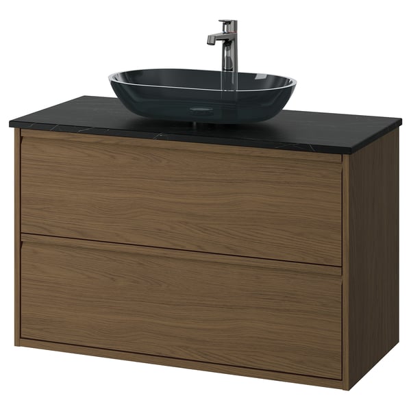 Modern bathroom vanity with walnut wood, black countertop, and glass sink.