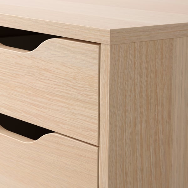 Close-up of wooden chest of drawers. Two drawers with sleek cut-out handles on castors, showcasing smooth finish and craftsmanship.