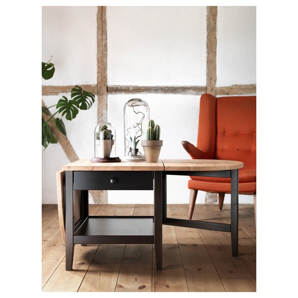 ARKELSTORP coffee table, black & light brown, single drawer, drop leaves. Minimalist room, bright orange chair.