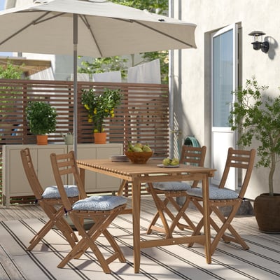 ASKHOLMEN outdoor dining set with wooden table, four gray cushioned chairs, beige umbrella, and potted plants on deck.