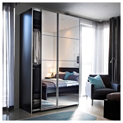 Modern bedroom with large mirror closet, reflecting a bed with blue pillows and a gray chair.