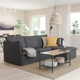 Modern living room with dark gray sofa, coffee table, pendant lamp, and window.