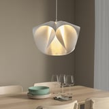 BÄCKNATE pendant lamp with white, flower-like shade above dining table, casting warm glow.