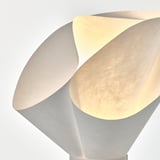 Modern table lamp with warm, soft light and intricate design.