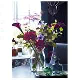 Elegant vase with colorful flowers, glass, clear, cylindrical, dark room, decorative.