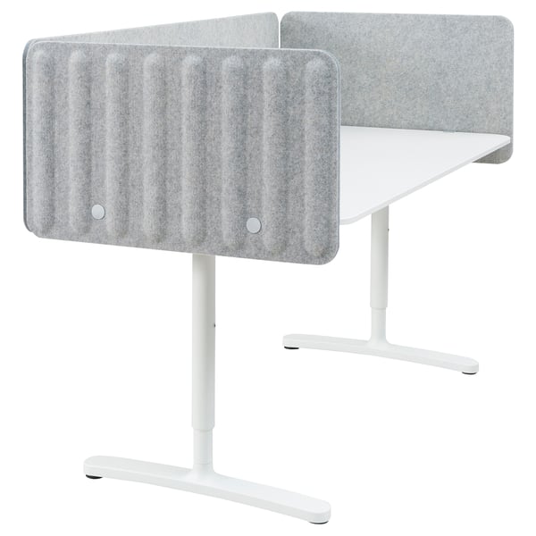 Two white modern office desks with adjustable white legs, each with a gray sound-absorbing screen attached to the back.