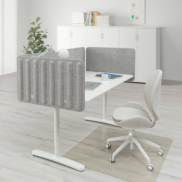 BEKANT office desk with white chair, gray screen, cable management, and wall storage.