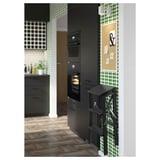 Modern kitchen with black cabinets, green patterned wallpaper, and a black beechwood folding step ladder.