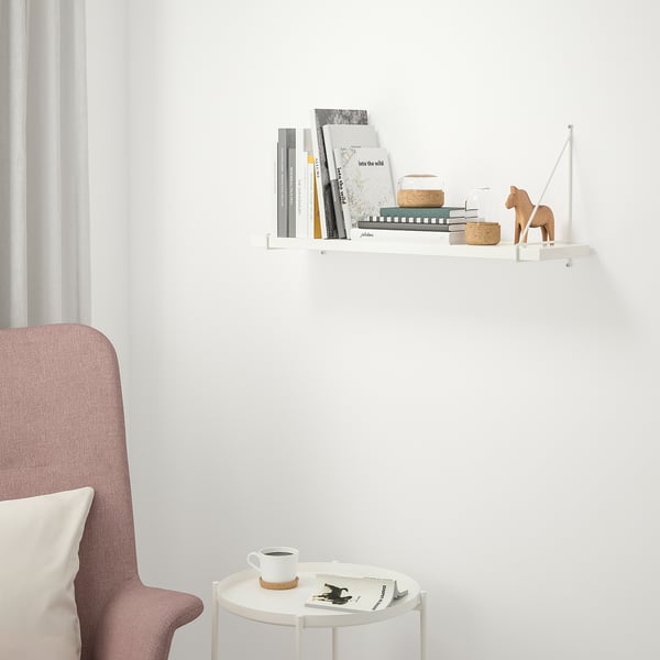 White BERGSHULT shelf with books, decor, and chair.
