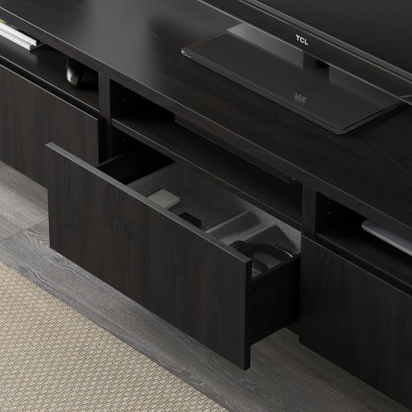 Open tv stand drawer revealing cables and media devices, showing storage and organization.