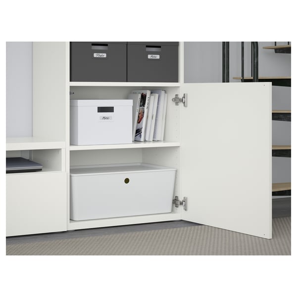 White storage unit with labeled boxes and a stack of magazines. A drawer and shelf are visible, showing organized storage.
