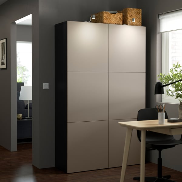Large, minimalist BESTÅ storage unit in beige, fitting between doorway & desk, with wicker baskets on top.