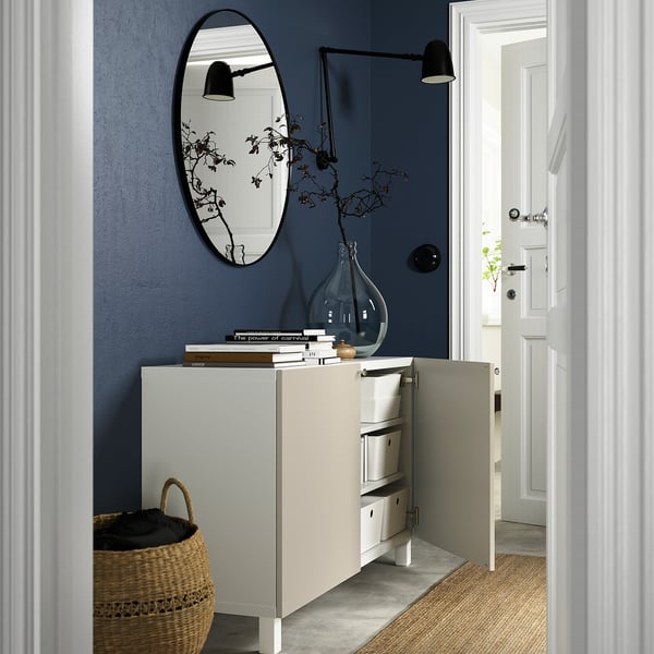 Sideboard with books, flowers, mirror, lamp, basket. 147 characters