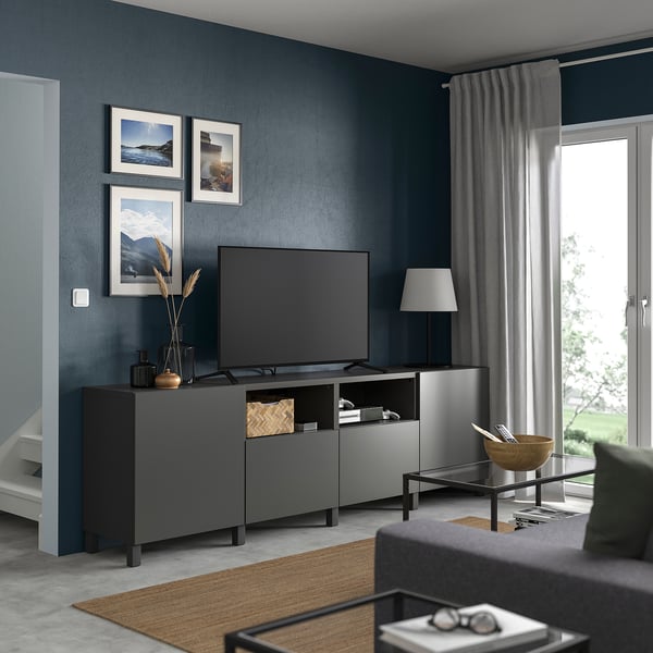 Modern living room with BESTÅ grey tv unit, flat-screen tv, decorative items, and large window with curtains.