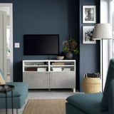 Modern living room with BESTÅ tv bench, blue sofa, wicker basket.