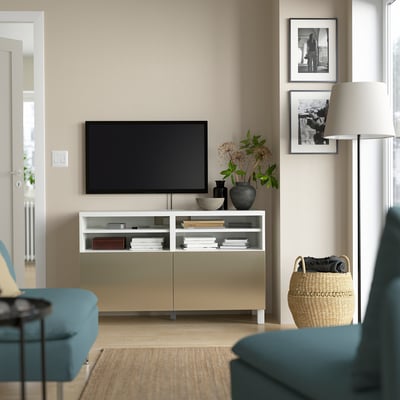 Modern living room with white BESTÅ tv stand, flat screen tv, turquoise sofa, woven basket, lamp, and black & white art.