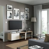 Modern living room with tv, decor, and large window.