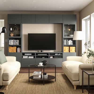 Modern living room with gray BESTÅ tv bench, white sofas, glass coffee table, and wooden flooring.