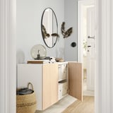 Modern entryway with white BESTÅ wall-mounted cabinet, round mirror, globe light, and woven basket.