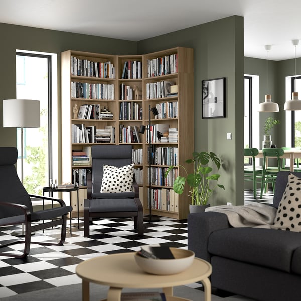 Modern living room with BILLY bookcase, grey armchairs, black & white checkered floor, light wood finish, and cozy decor.