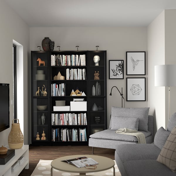 Modern living room with BILLY black bookshelf, grey sofa, and lamp.