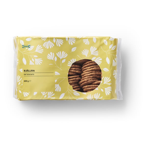 A pack of IKEA BJÄLLRA oat biscuits, 600g. Yellow packaging with flower designs and a circular window showing the cookies.