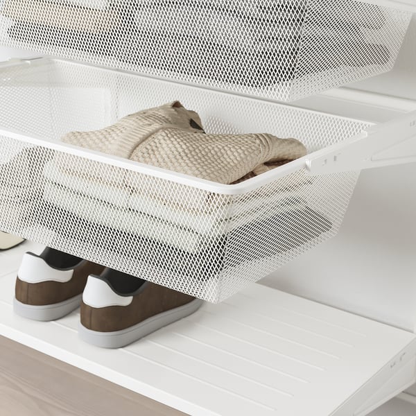 White mesh storage drawer, part of BOAXEL system, holding folded clothes. Its pull-out for easy access.