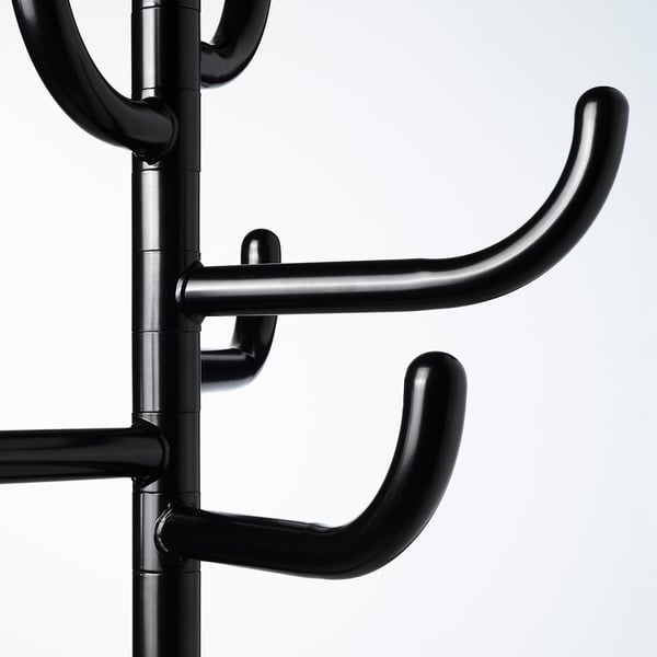 Black metal coat stand close-up, showing sturdy hooks and robust construction.