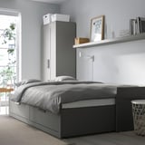 Minimalist bedroom with BRIMNES day-bed, storage, and tall wardrobe.
